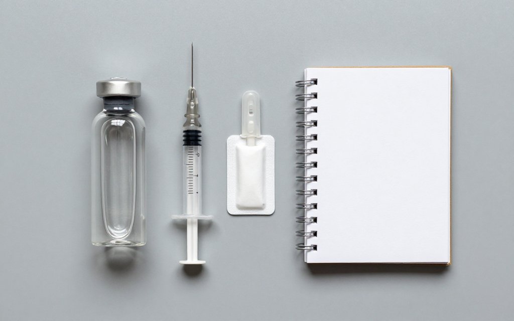 Top-down flat lay of a semaglutide vial and syringe for a dosage chart in units.