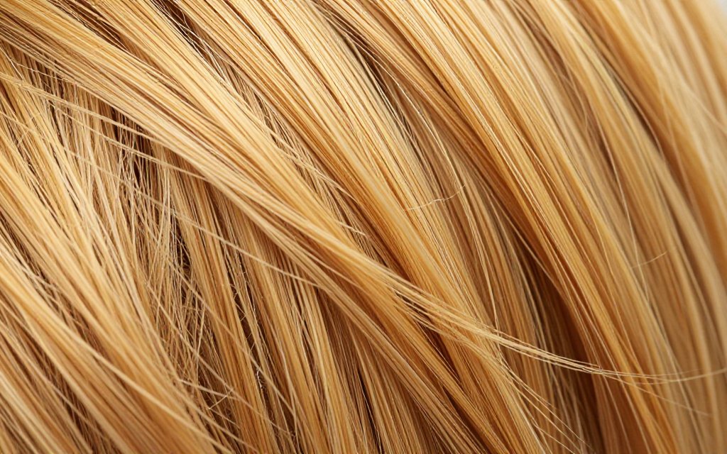 Close-up of brassy yellow and orange tones running through blonde strands