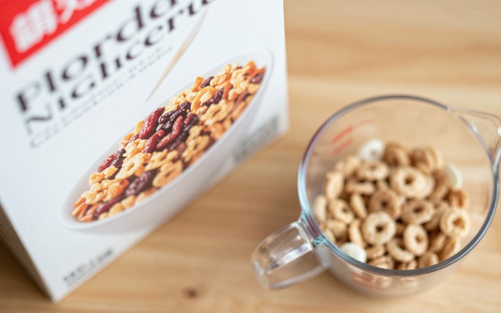 Serving size shown with a measuring cup beside a food package and cereal