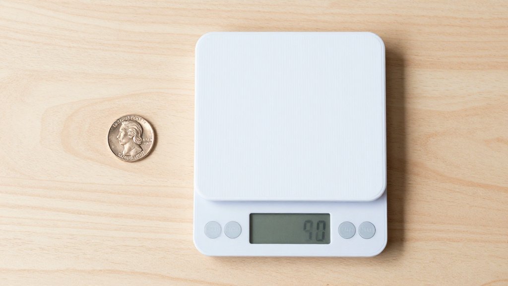 A nickel beside a digital kitchen scale ready for a two minute calibration check