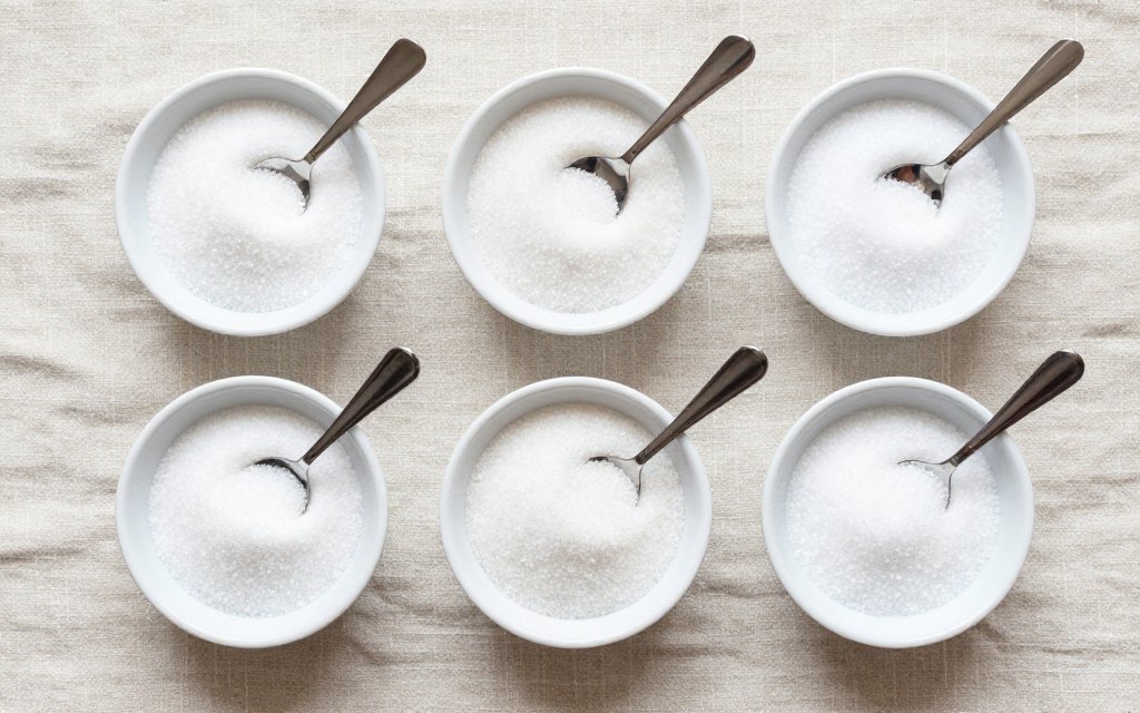 Top down view of measured sugar portions showing how much sugar per day guidelines allow