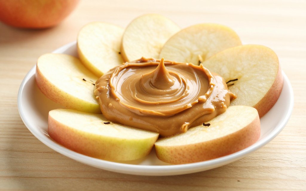 Peanut butter spread thin on apple slices as a filling, portion controlled snack