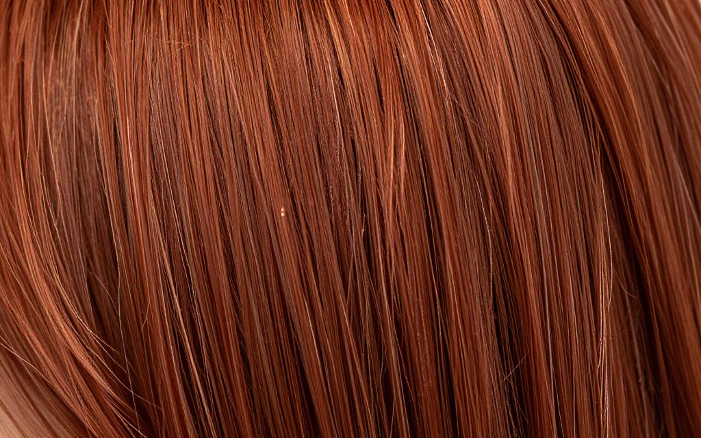 Macro close up of copper hair color strands showing shine