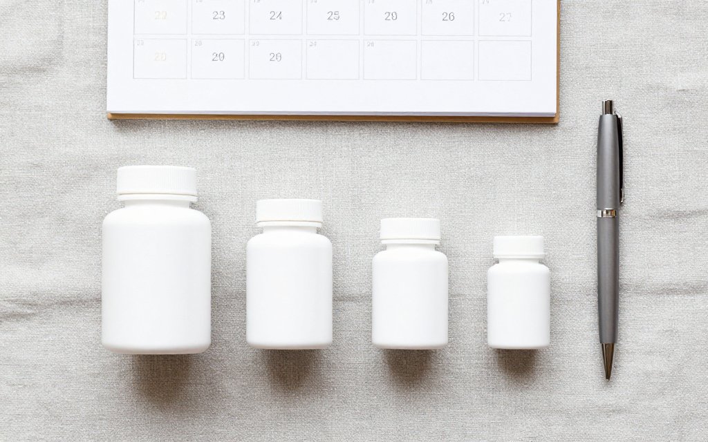 Four unlabeled pill bottles in a row representing the Wegovy pill dosage ladder from 1.5 mg to 25 mg