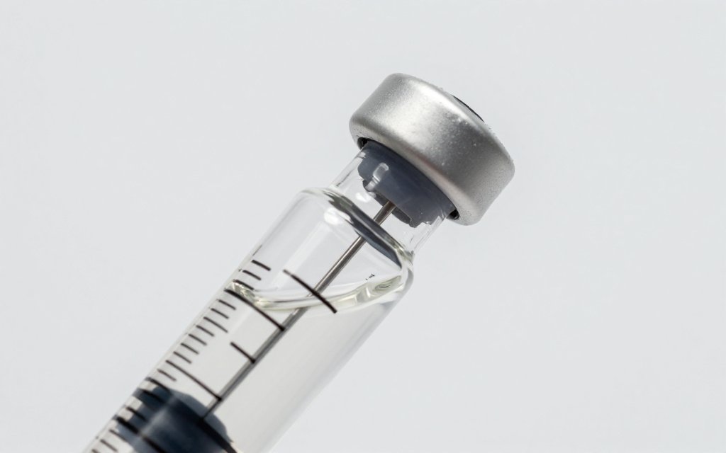 Macro view of a syringe drawing liquid from an inverted vial, following Zepbound vial instructions